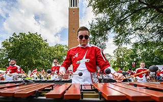 a Million Dollar Band member performs on the UA Quad with Denny Chimes in the background